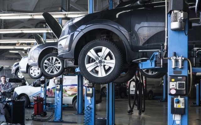 整備中の自動車が引き上げられている自動車整備工場