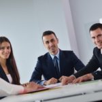 スーツ姿のビジネスマンとビジネスウーマンが笑顔で正面を向いている