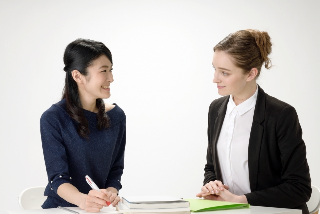 外国人講師から外国語のレッスンを受ける日本人女性