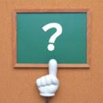 黒板に書かれたクエスチョンマークと指さし棒