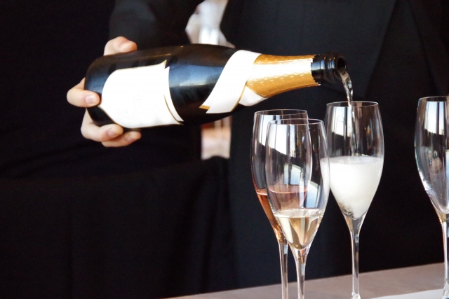 シャンパンをグラスに注ぐワインソムリエ