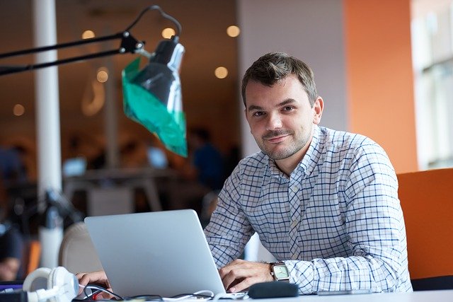 オフィスでノートパソコンを開いている若い起業家