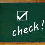 黒板に白いチョークで書かれたcheck!の文字