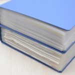 表紙が青色の分厚いフォルダーが2つ重ね置かれている