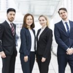 国際色豊かなスタッフが笑顔で並んで立っている