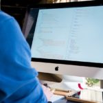 デスクトップパソコンの画面を見ながら作業中のITエンジニア