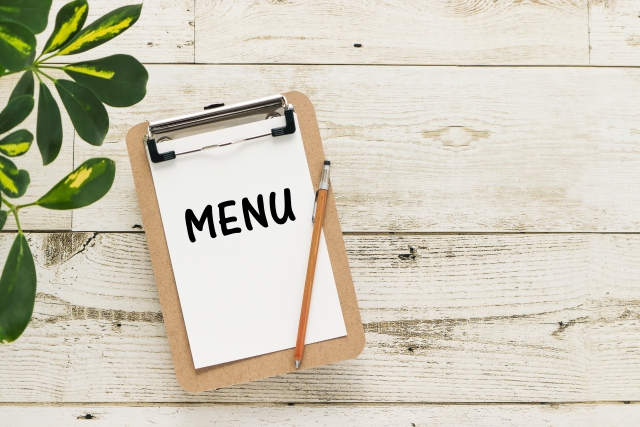 クリップボードに留められたメニューと鉛筆