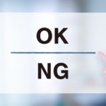 紙に書かれたOKとNGの文字を人差し指で指している