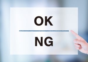 紙に書かれたOKとNGの文字を人差し指で指している