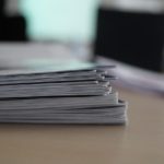 オフィスの机の上に重ね置かれた書類