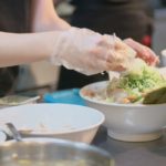 厨房でラーメンを調理している