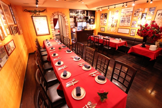 赤いテーブルクロスが敷かれたテーブルと椅子が並んだレストラン店内