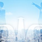 都会の街並みを背景にした2人のシルエットと3本の道筋