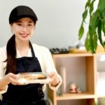 笑顔の店員が弁当を客に手渡している