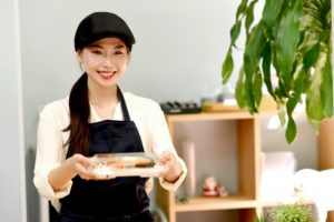 笑顔の店員が弁当を客に手渡している