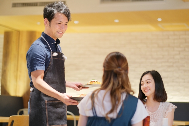 カフェで客に食事を運ぶウェイター