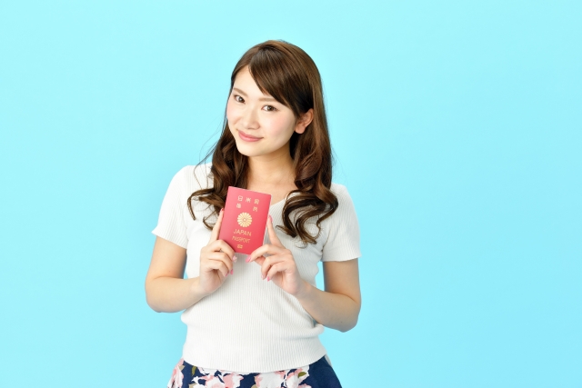 パスポートを手にする笑顔の女性