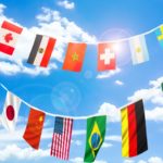 様々な国の国旗が青空を背景にはためいている