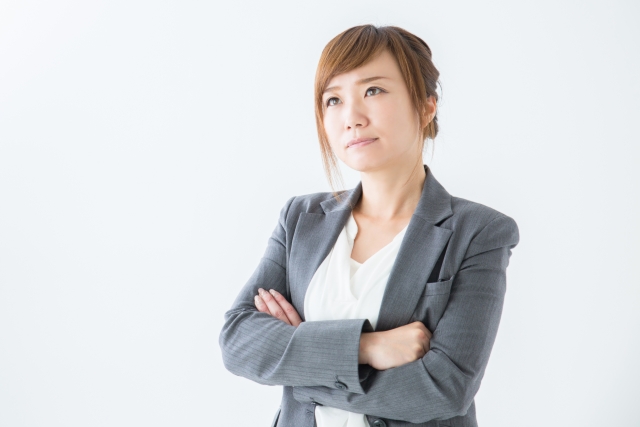 グレーのスーツ姿の女性が何かを悩んでいる